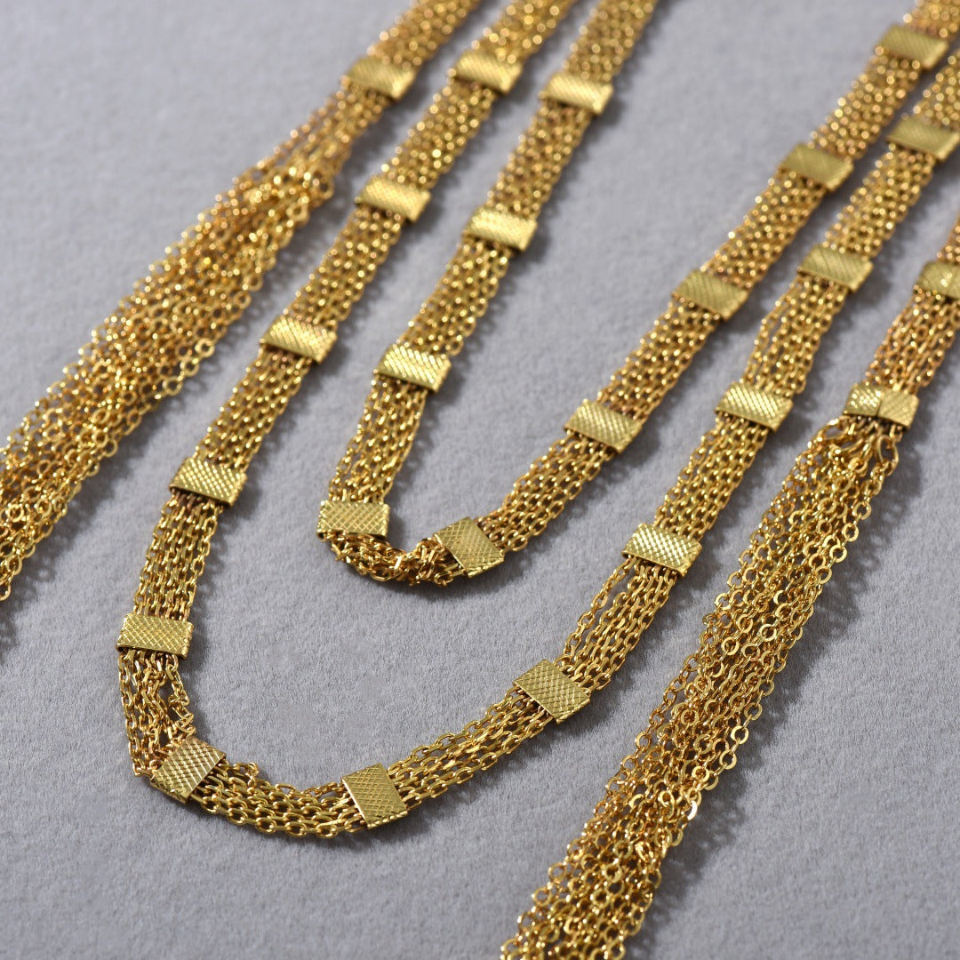 Collana lunga a strati con nappina quadrata dorata