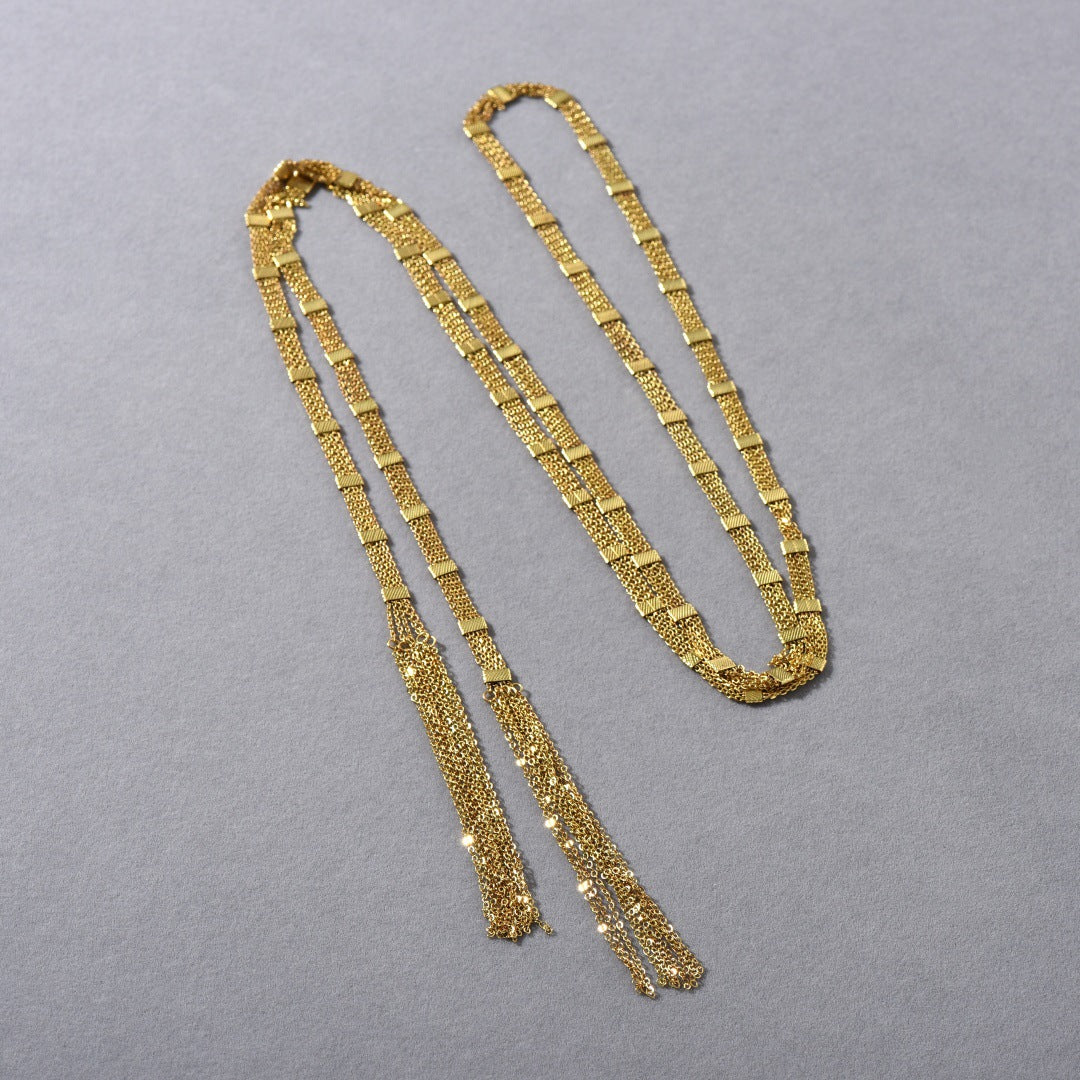 Collana lunga a strati con nappina quadrata dorata