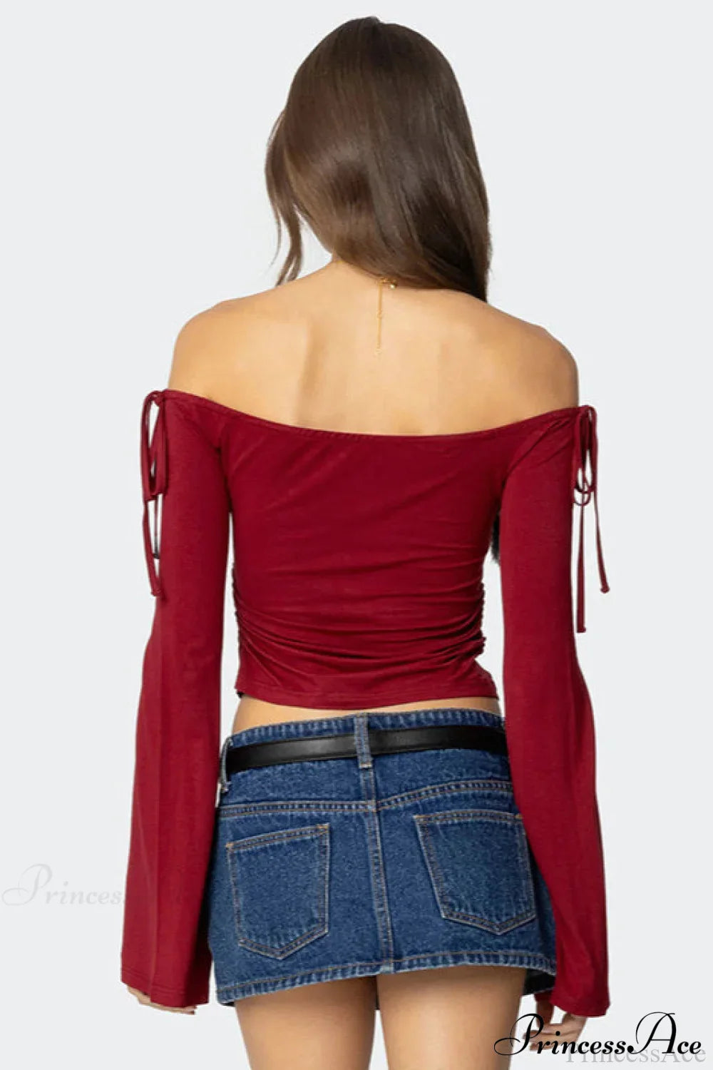 Top corto de manga larga con hombros descubiertos y lazo en el cuello