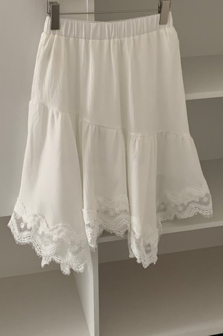 Modischer eleganter asymmetrischer Midirock mit Spitzenbesatz