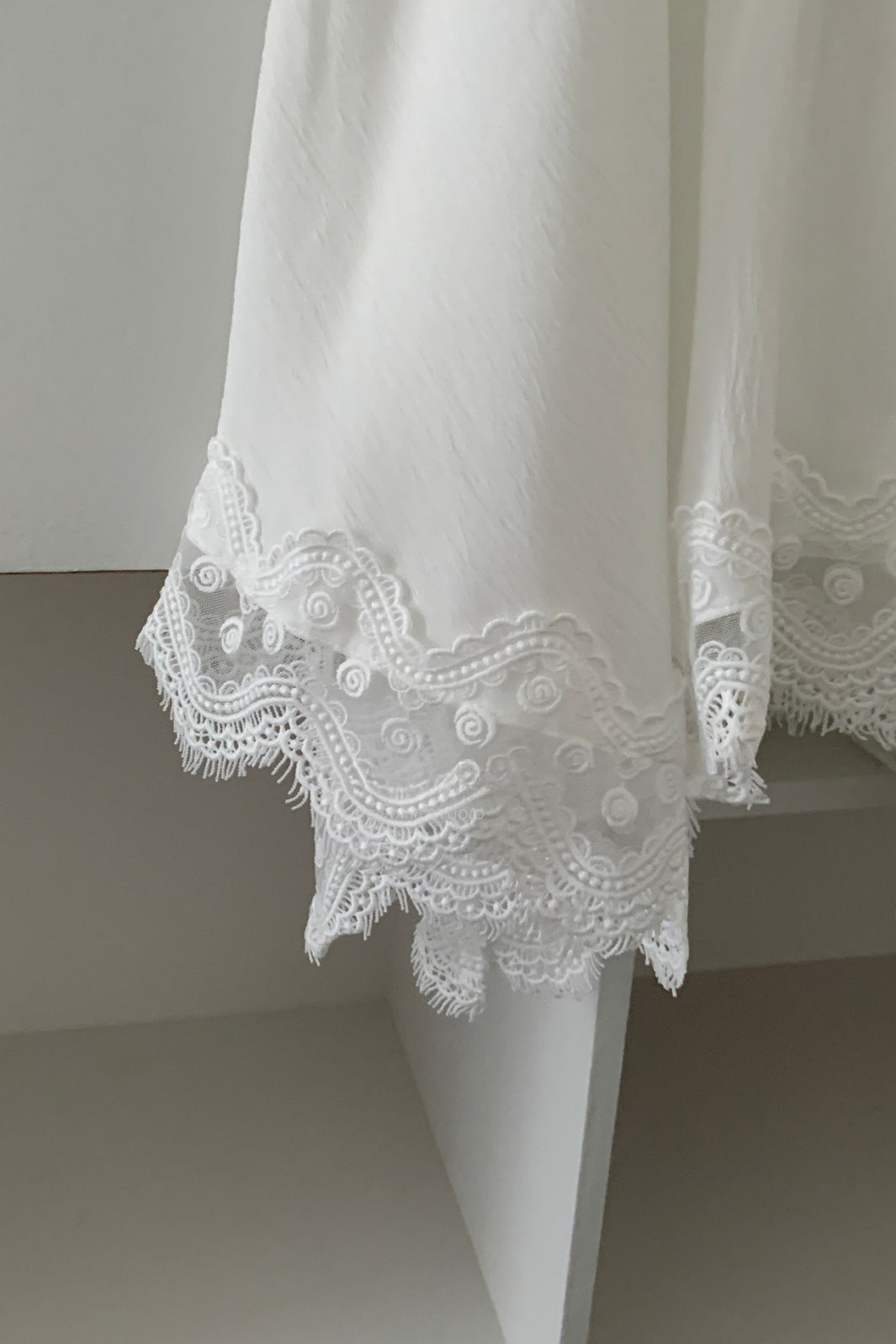 Modischer eleganter asymmetrischer Midirock mit Spitzenbesatz