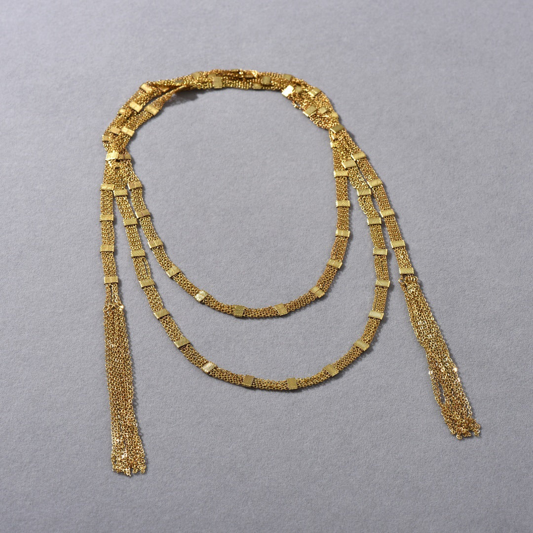 Collana lunga a strati con nappina quadrata dorata